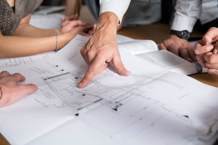 Projektleiter bespricht Baupläne mit dem Team